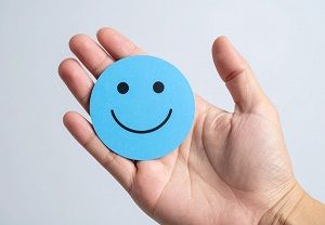 Eine Hand hält eine Smiley-Karte